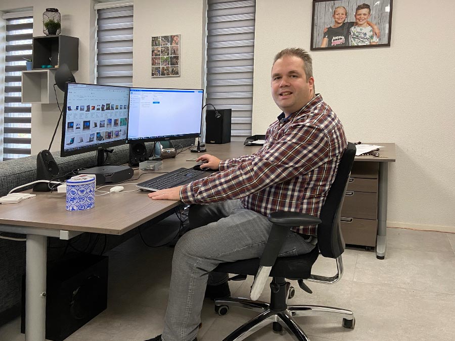 Thijs op kantoor met een Apple computer met dubbel beeldscherm